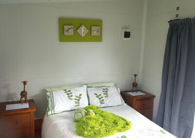 Interior of portable cabin furnished with a double bed and side tables